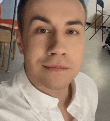 a close up of a man 's face with a white shirt on