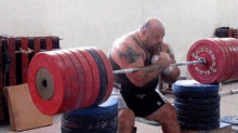 a man is squatting down holding a barbell with a red weight plate that says ' elight ' on it