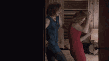 two women in dresses are dancing on a bed in a room .