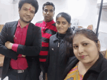 a group of people posing for a picture with one of them wearing a jacket with the letter r on the front