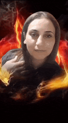 a woman is surrounded by flames and smoke in a dark room