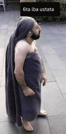 a man wrapped in a towel with the words 6ta iba ustata written above him