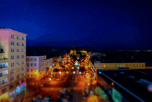 an aerial view of a city at night with a purple building in the foreground