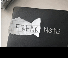 a black book with a piece of paper that says freak note on it