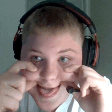 a young boy wearing headphones making a funny face