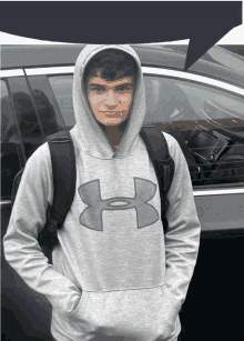 a young man wearing a grey under armour hoodie