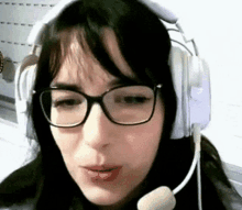 a woman wearing glasses and headphones with a microphone is talking .