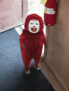 a child in a red costume is walking down a hallway