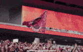 a crowd of people in a stadium watching a game with a flag that says ' barcelona ' on it