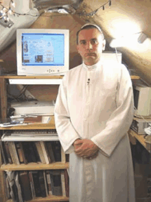 a man in a white robe is standing in front of a computer