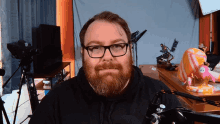 a man with a beard wearing glasses and a black hoodie