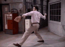 a man in a white shirt is throwing a baseball in front of a vending machine that says coca cola