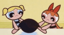 bubbles and blossom from the powerpuff girls are holding a black ball .