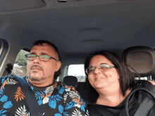 a man and a woman are sitting in a car and smiling