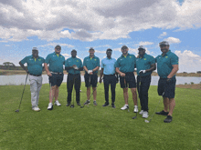 a group of men standing on a golf course with their clubs