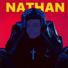 a man with a cross on his neck is on a red background with the name nathan