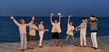 a group of young men are holding sparklers on the beach