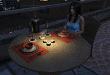 a woman sits at a table with plates and candles on it