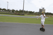 a boy wearing sunglasses and a yellow helmet rides a segway on a road