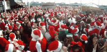 a crowd of people dressed in santa hats are gathered in front of a building that says ' fisherman '