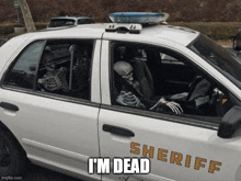 a sheriff 's car with two skeletons in it