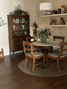 a dining room with a table and chairs with a vase of flowers on the table