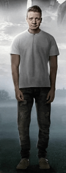 a man in a white shirt and jeans is standing in a foggy field