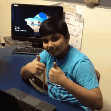 a boy giving a thumbs up in front of a computer monitor that says 2:40 on it