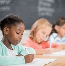 a group of children are sitting at their desks in a classroom writing in notebooks .