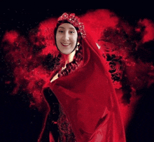 a woman is wearing a red cape and a red crown