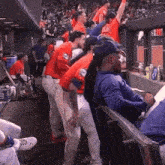 a group of baseball players are standing in a dugout and one of them is wearing a jersey with the letter l on it