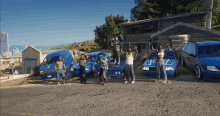 a group of people are posing for a picture in front of a house with a van that says ' u ' on it