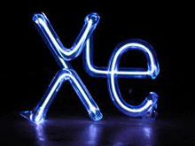 a neon sign that says xe on a dark background .