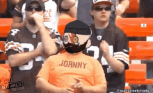 a man with a beard wearing an orange shirt that says johnny on it