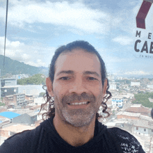 a man smiles in front of a sign that says me cae en movi