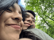 a man and a woman are looking up at trees