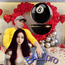 a man and a woman are posing in front of balloons and a pool ball that says ball pro