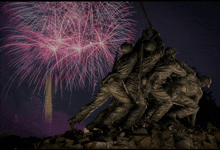 a statue of soldiers is surrounded by fireworks