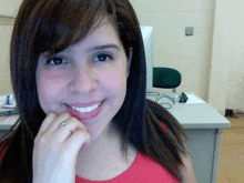 a woman with a ring on her finger smiles in front of a computer