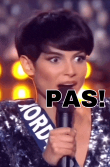 a woman in a sequined top is holding a microphone with the word pas written on it