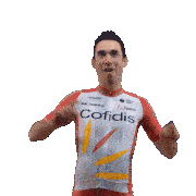 a man in a red and white cofidis jersey holds his arms in the air