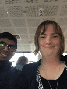 a man and a woman are posing for a picture and the woman is smiling