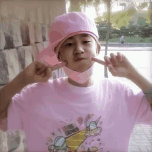 a young boy wearing a pink hat and a pink shirt that says genesis