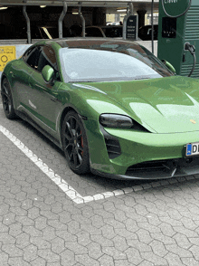 a green sports car is parked next to a sign that says clever