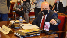 a man in a suit and tie is sitting at a table with a sign that says ' vladimir '