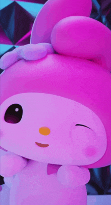 a close up of a pink stuffed animal with a yellow eye