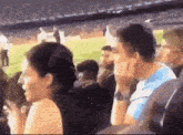 a group of people are sitting in a stadium watching a soccer game