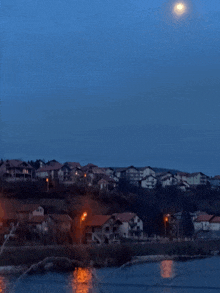 a full moon shines over a small town