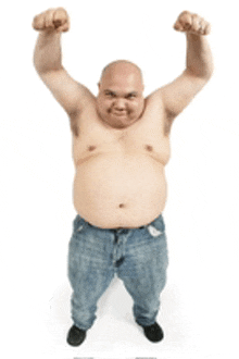 a shirtless bald man in blue jeans is raising his fist in the air