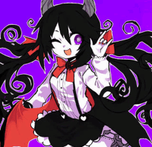 a girl with long black hair and horns is sitting on a purple surface .